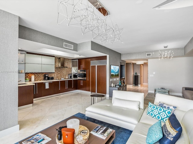 living area with baseboards, a chandelier, and visible vents