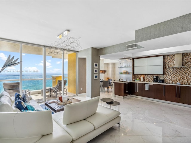 living area with a water view, floor to ceiling windows, marble finish floor, and visible vents