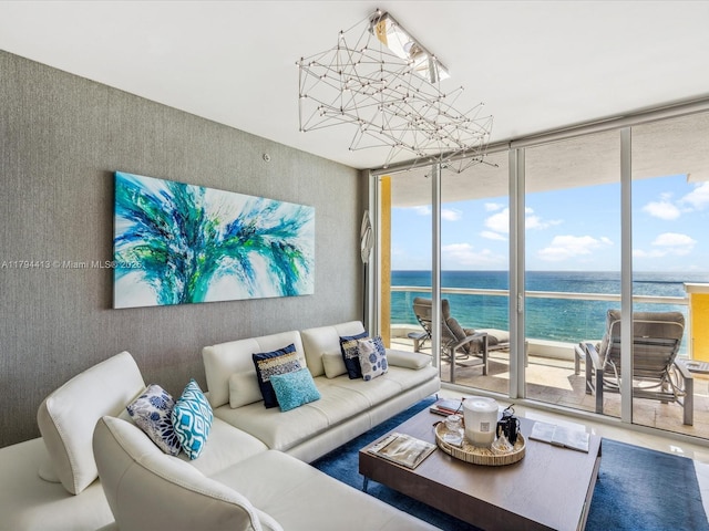 living room featuring a water view, a wall of windows, and an inviting chandelier