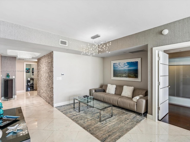 living room with baseboards, tile patterned flooring, a notable chandelier, and visible vents