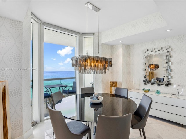 dining room with a water view and expansive windows