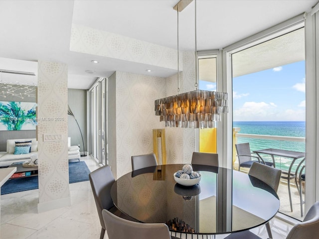 dining space featuring a water view and wallpapered walls