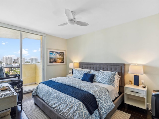 bedroom with a view of city, access to outside, a ceiling fan, and wood finished floors