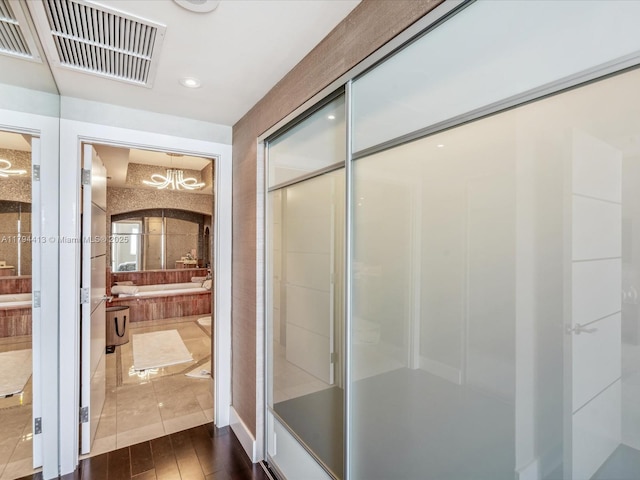 bathroom featuring visible vents, an enclosed shower, wood finished floors, vanity, and an inviting chandelier