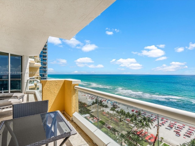 balcony with a water view and a beach view