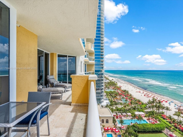 balcony featuring a beach view and a water view