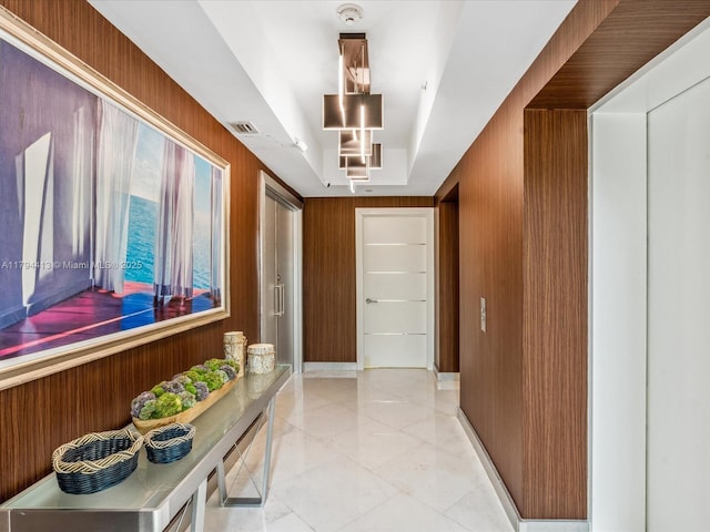 corridor featuring visible vents and wood walls