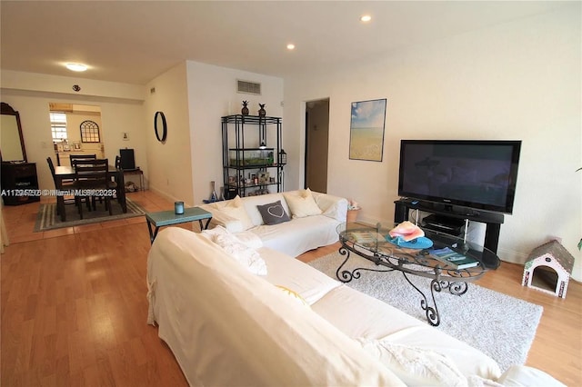 living room featuring visible vents, recessed lighting, baseboards, and wood finished floors