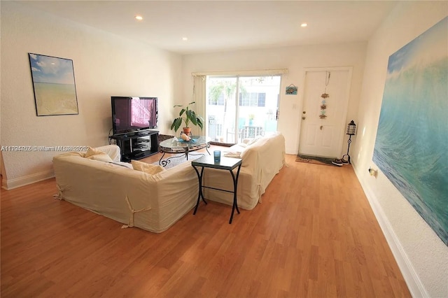 living room featuring baseboards, recessed lighting, and light wood-style flooring