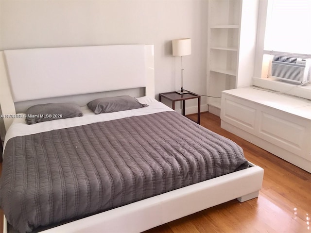 bedroom featuring light wood-style flooring and cooling unit
