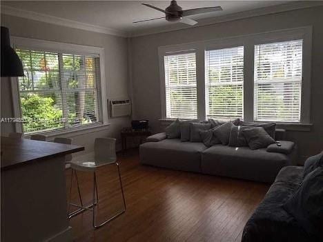 living room featuring crown molding, ceiling fan, plenty of natural light, and wood finished floors