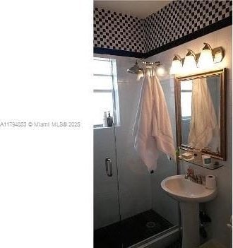 full bath with a stall shower and wallpapered walls