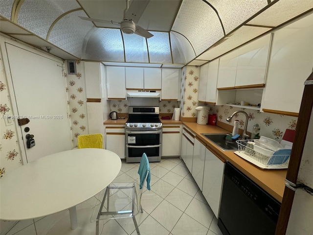 kitchen featuring a sink, black dishwasher, double oven range, and wallpapered walls