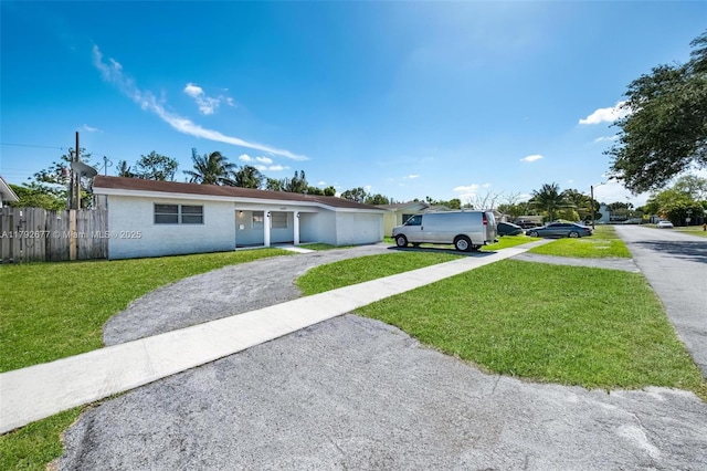 6620 NW 21st Ct, Sunrise, FL 33313 - ranch-style home featuring a garage, fence, a front yard, stucco siding, and driveway