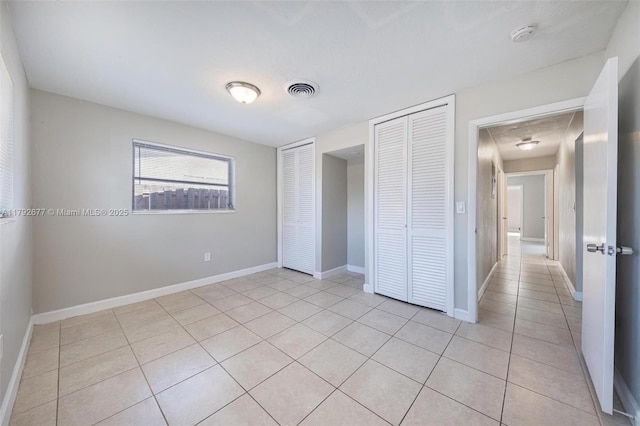 6620 NW 21st Ct, Sunrise, FL 33313 - unfurnished bedroom with visible vents, baseboards, multiple closets, and light tile patterned floors