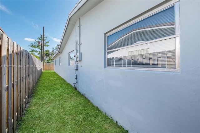 6620 NW 21st Ct, Sunrise, FL 33313 - view of side of home featuring a lawn, fence, and stucco siding