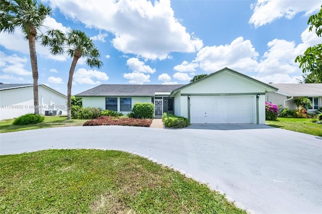ranch-style home with a garage, stucco siding, driveway, and a front yard