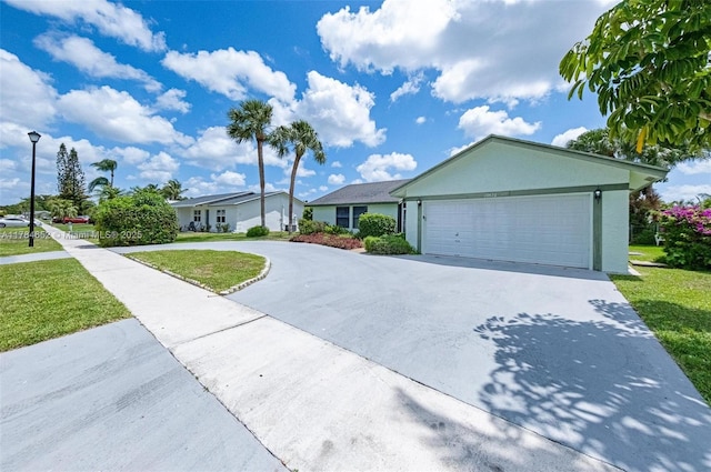 single story home with a garage, stucco siding, driveway, and a front lawn