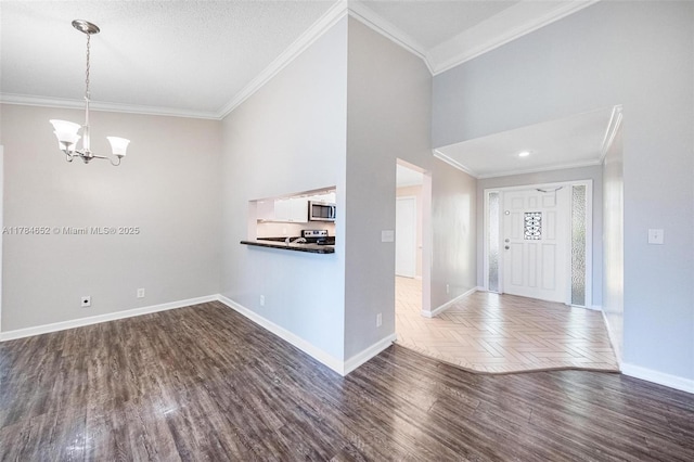 entryway with crown molding, baseboards, a notable chandelier, and dark wood-style floors