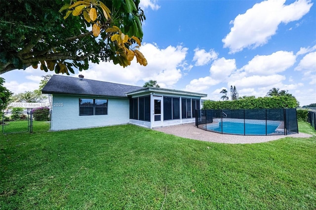 back of house with a fenced backyard, a lawn, a fenced in pool, and a sunroom