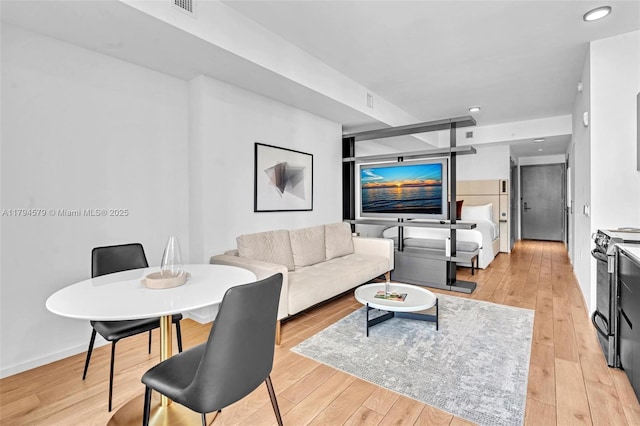 living area featuring light wood-type flooring, recessed lighting, and baseboards