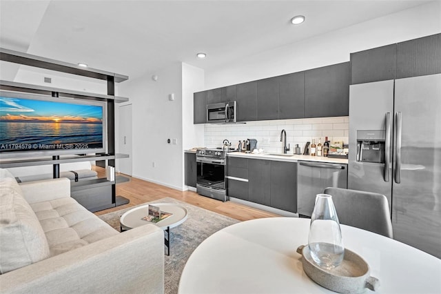 living room with light wood-style floors, baseboards, and recessed lighting