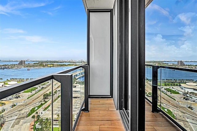balcony featuring a water view and a city view