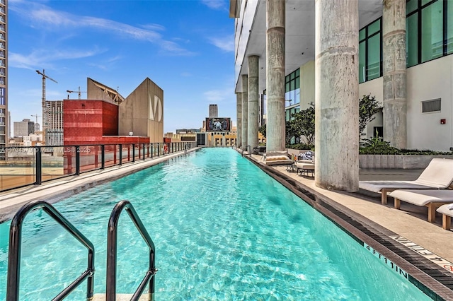 community pool with a patio area and a city view
