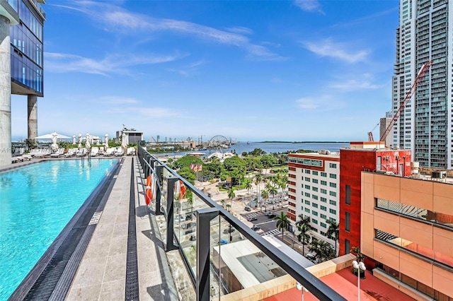 view of swimming pool featuring a water view and a city view