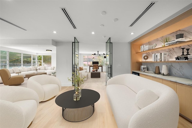 living room with recessed lighting, visible vents, and light wood-type flooring
