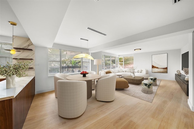 dining area featuring a ceiling fan, visible vents, a wealth of natural light, and light wood-style flooring