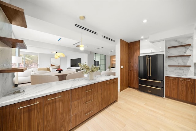 kitchen with high end black refrigerator, modern cabinets, open shelves, light stone countertops, and open floor plan