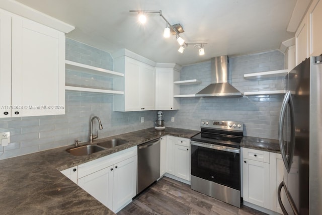 kitchen with open shelves, a sink, wall chimney exhaust hood, stainless steel appliances, and decorative backsplash