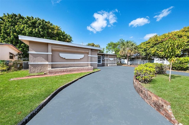 6421 NW 24th Pl, Sunrise, FL 33313 - view of front of home featuring central air condition unit, stucco siding, a front yard, and fence
