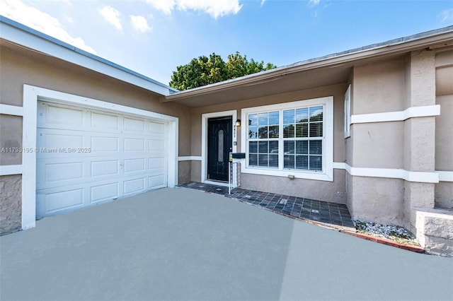 6421 NW 24th Pl, Sunrise, FL 33313 - view of exterior entry featuring an attached garage, stucco siding, and concrete driveway