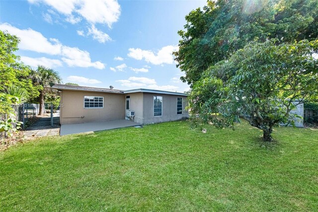 6421 NW 24th Pl, Sunrise, FL 33313 - rear view of property with a lawn, fence, a patio, and stucco siding