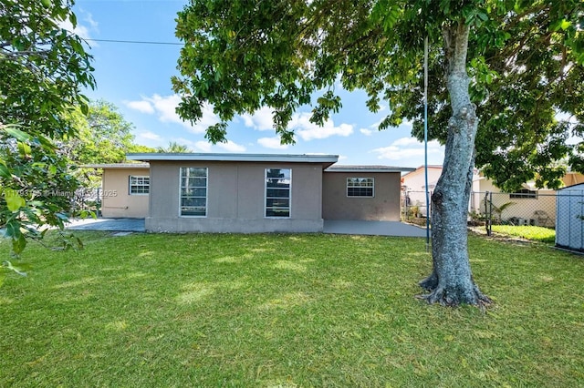 6421 NW 24th Pl, Sunrise, FL 33313 - rear view of property featuring a lawn, a patio, fence, and stucco siding