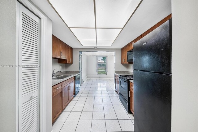 6421 NW 24th Pl, Sunrise, FL 33313 - kitchen featuring brown cabinets, a sink, light countertops, light tile patterned floors, and black appliances