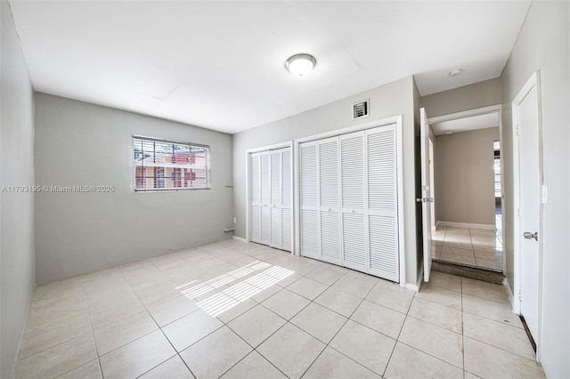 6421 NW 24th Pl, Sunrise, FL 33313 - unfurnished bedroom with light tile patterned floors, multiple closets, and visible vents
