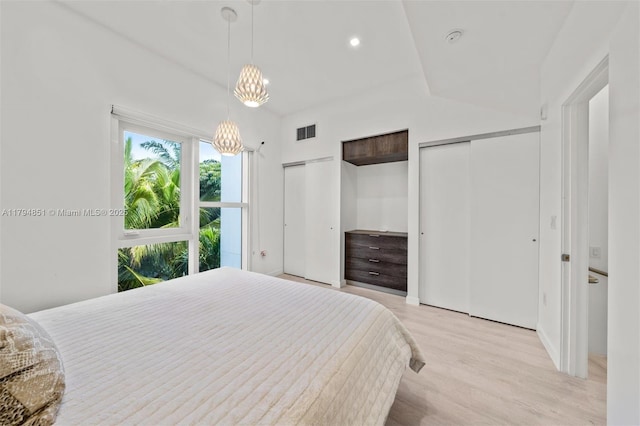 bedroom with visible vents, multiple closets, light wood-style floors, recessed lighting, and a chandelier