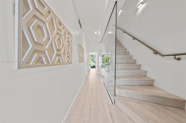 staircase featuring baseboards, recessed lighting, and wood finished floors