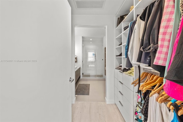 walk in closet featuring light wood-style flooring and visible vents
