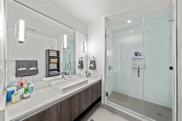 bathroom with vanity, visible vents, and a stall shower