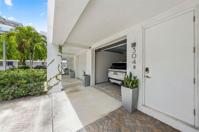 entrance to property with stucco siding and a garage
