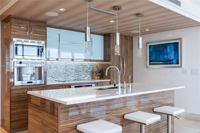 5875 Collins Ave Unit 1908, Miami Beach, FL 33140 - kitchen featuring brown cabinets, backsplash, a sink, and modern cabinets