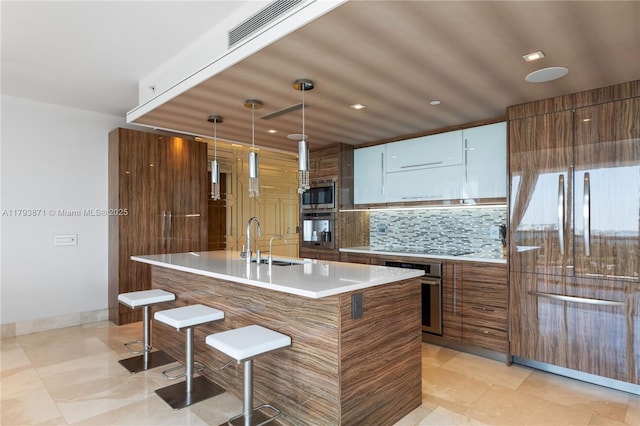5875 Collins Ave Unit 1908, Miami Beach, FL 33140 - kitchen with a breakfast bar area, visible vents, appliances with stainless steel finishes, modern cabinets, and a sink