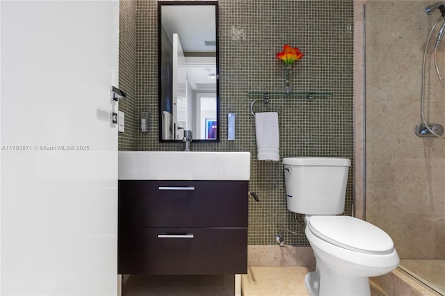5875 Collins Ave Unit 1908, Miami Beach, FL 33140 - bathroom featuring tile walls, tile patterned flooring, a tile shower, vanity, and toilet