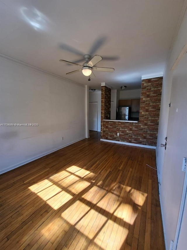 unfurnished living room featuring crown molding, a ceiling fan, baseboards, and hardwood / wood-style flooring
