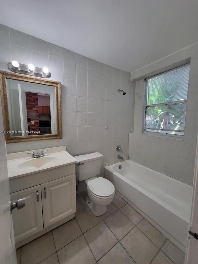 full bathroom featuring washtub / shower combination, vanity, toilet, tile patterned floors, and tile walls