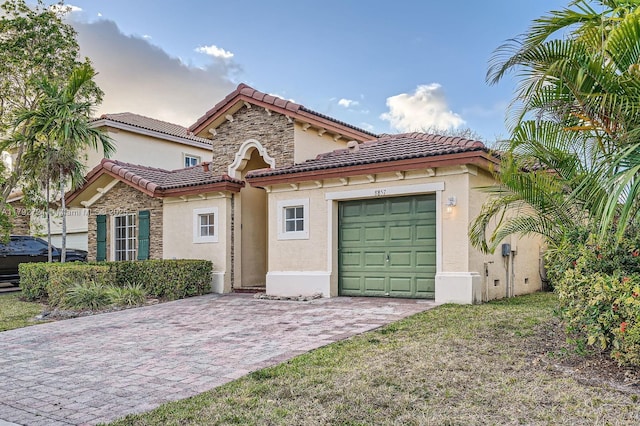 8857 SW 222nd Ter, Cutler Bay, FL 33190 - mediterranean / spanish-style home with stone siding, a garage, stucco siding, decorative driveway, and a tiled roof